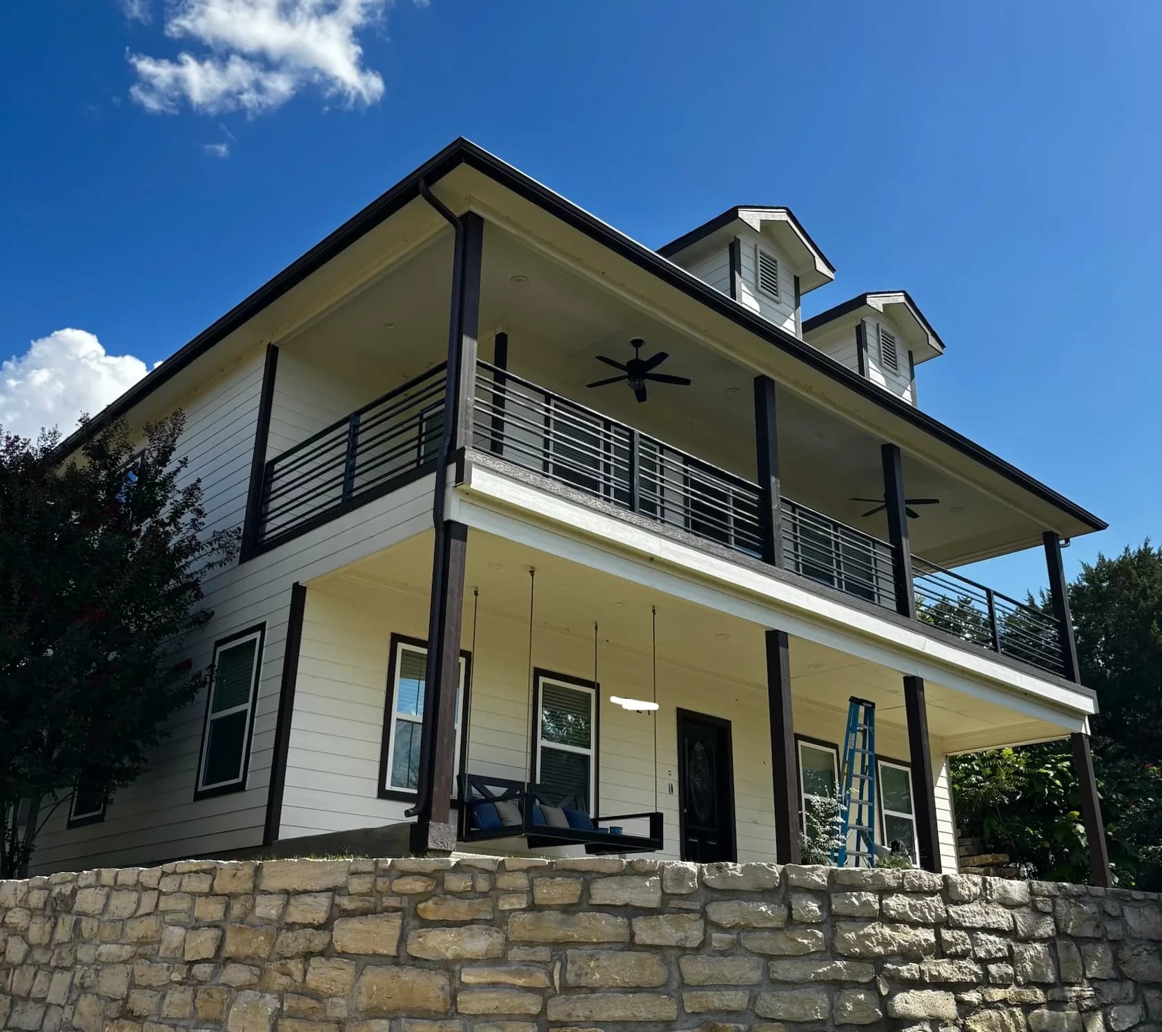 Dark seamless gutters installed on a two story home