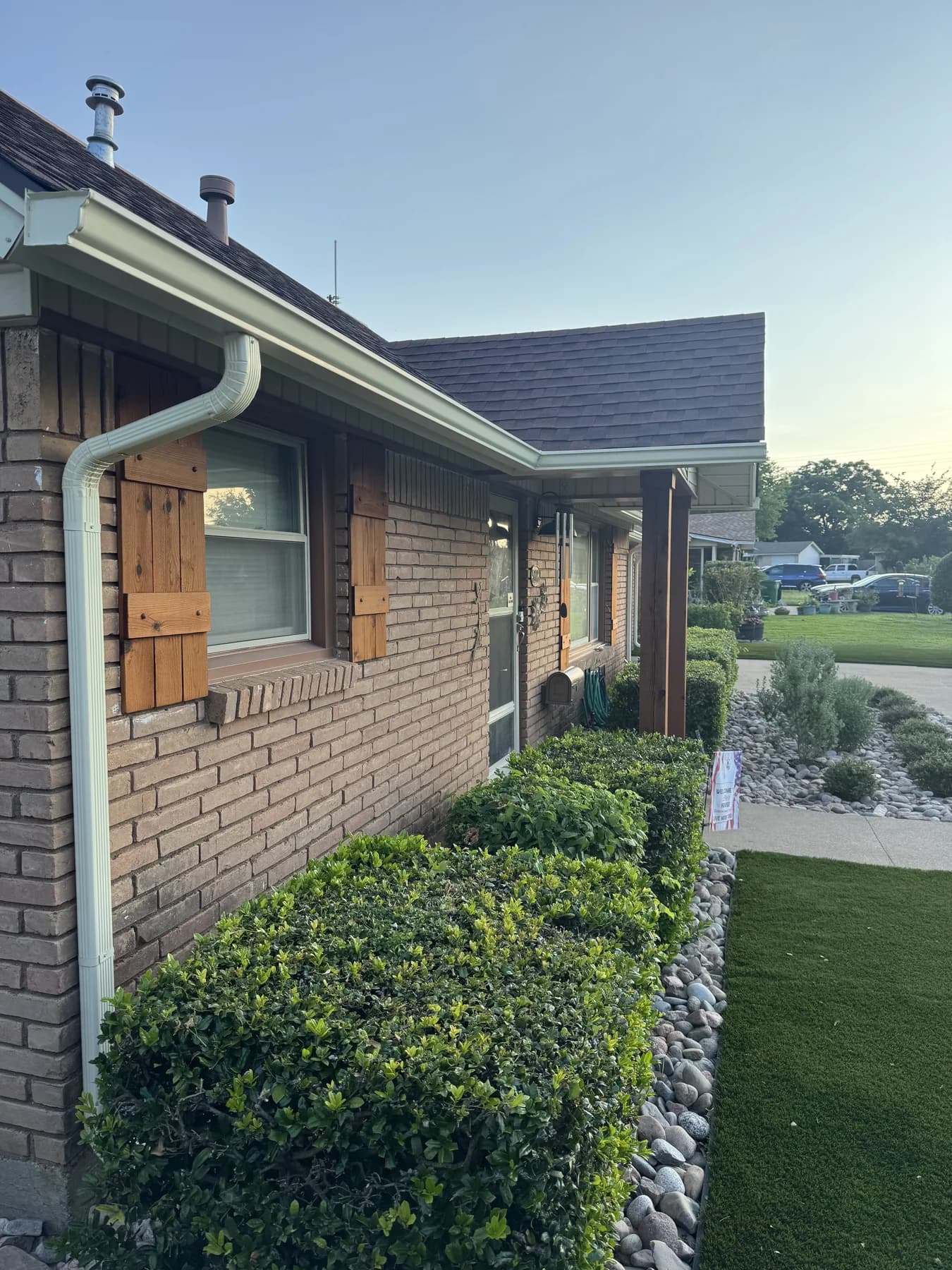 White gutters installed on a brick home front porch